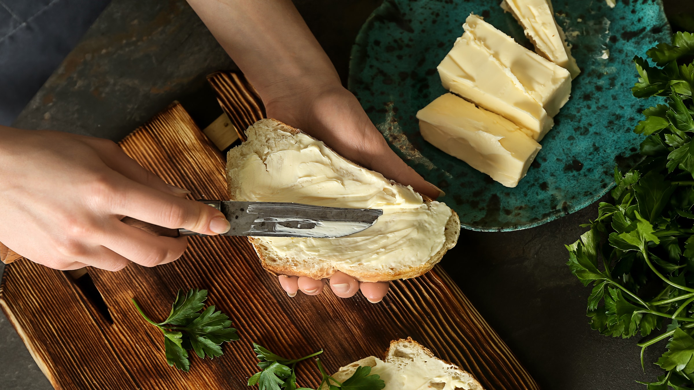 Butter wird mit einem Messer auf ein Brot gestrichen