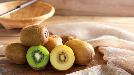 Kiwis ganz und aufgeschnitten liegend