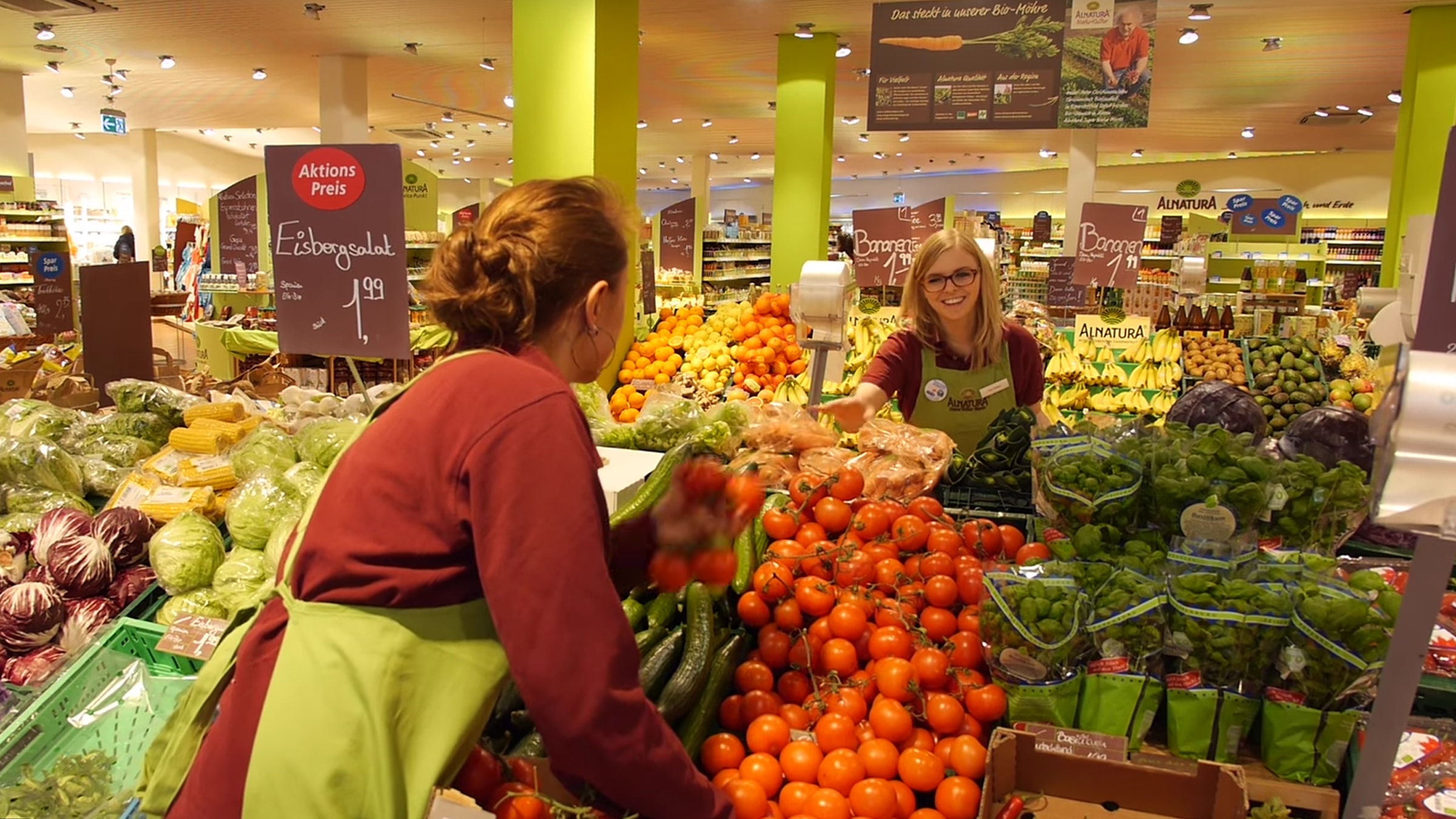 Lehrlinge bei Alnatura räumen Obst und Gemüse ein